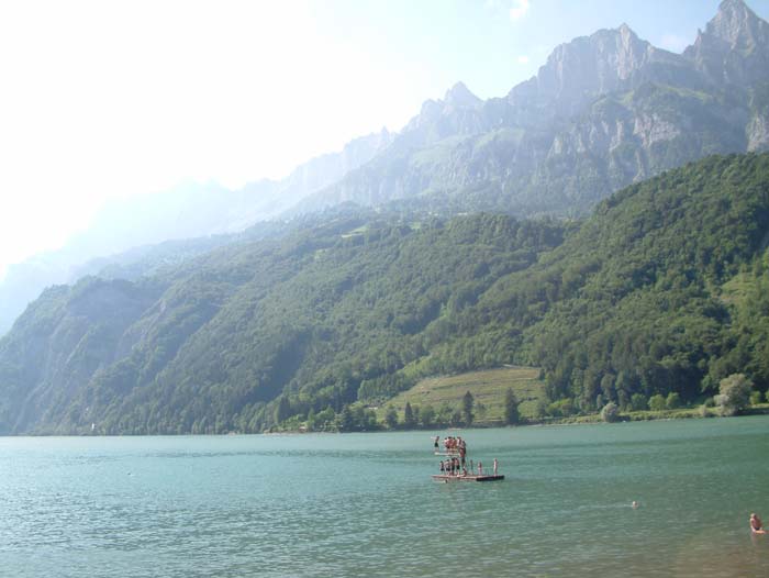Einige Schwimmer im Walensee. Umgeben ist die Szenerie von der beeindruckenden Kulisse der Schweizer Alpen.