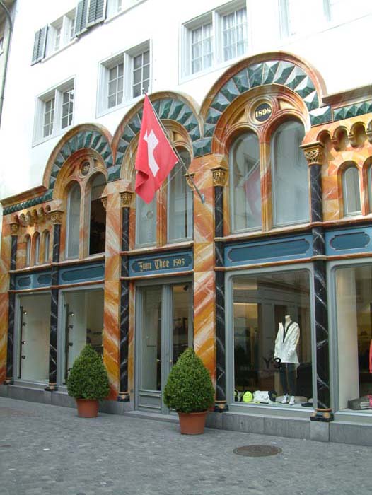 Modegeschäft in historischem Gebäude mit schweizer Flagge über dem Eingang