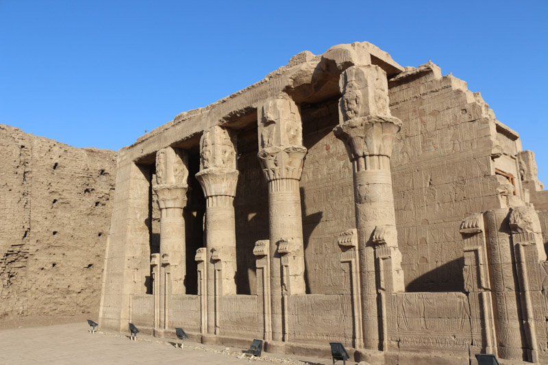 Etwa 60 Meter südwestlich des Hauptportals steht vor dem Pylon des Tempels von Edfu ein kleines, mit Säulen flankiertes Gebäude. Das eingeschossige Bauwerk war ein Heiligtum der Göttin Hathor von Dendara.

Das in ptolemäischer Zeit als Hut-Chenmet („Haus der Amme“) bezeichnete Gebäude war ein so genanntes „Geburtshaus“, ein Mammisi (aus dem Koptischen, „Ort der Geburt“ bedeutend). Im Mammisi von Edfu wurde neben Hathor der Kindgott Hor-Semataui-pa-chered („Harsomtus, das Kind“) als Erbe des Hauptgottes von Edfu Hor-Behdeti verehrt. Hier erneuerte sich jährlich das Wunder der Geburt des Hor-pa-chered, weshalb dies auch ein heiliger Ort für schwangere Frauen war.
