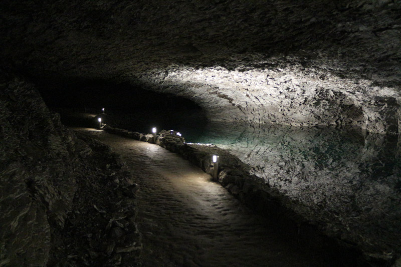 Ein schmaler Pfad des Lichts und ein Teich unter der unwirklichen Höhlendecke