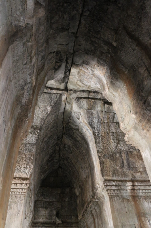 You can see that the ancient Khmer did not know the round arch. Instead they moved each layer of stones closer together to create a narrow vaulted ceiling. Therefore the possible width of the corridors was quite limited.