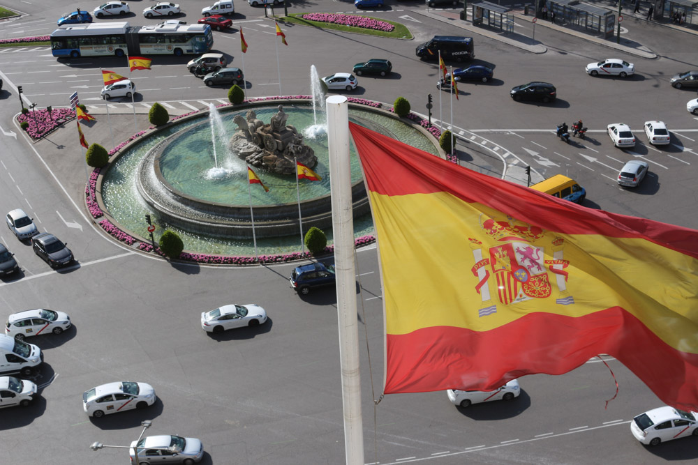 View from the top of Cybele Palace (Palacio de Cibeles) down to the Plaza de Cibeles in Madrid and the Spanish flag.