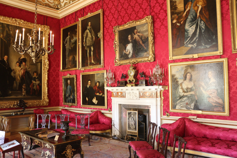 Red Drawing Room of Blenheim Palace with three paintings from Van Dyck around the fireplace. It was originally used as a billiard room and a library.