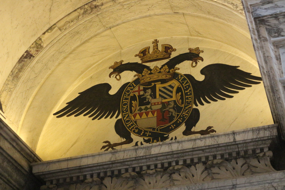 Shield of the The 1st Duke of Marlborough above the doors of the Great Saloon in Blenheim Palace. It shows the motto of the British chivalric Order of the Garter: "Honi soit qui mal y pense" which translates to "May he be shamed who thinks badly of it".