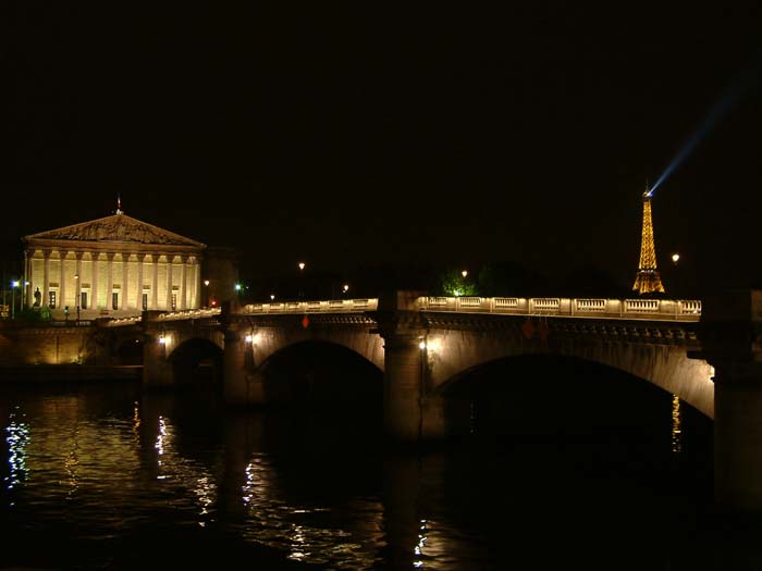 Die nächtlich beleutete Assemblée Nationale, den Pont de la Concorde und den Eiffelturm