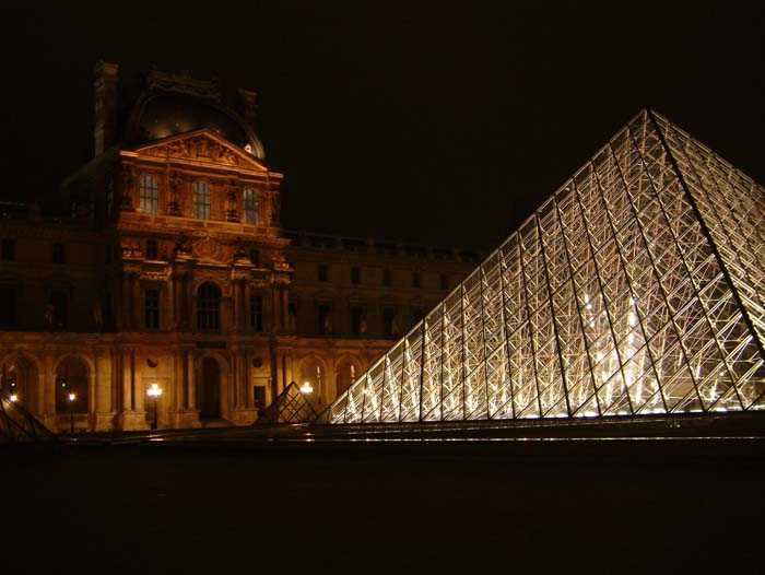 By night the Musée du Louvre is illuminated by thousands of small lights hidden in niches and protrusions of the baroque facade the magnificent museum.