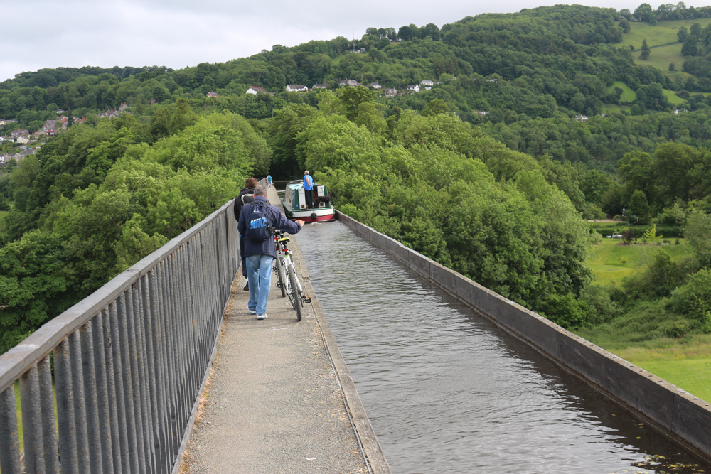 Narrowboat in der Fahrrinne des Pontcysyllte-Aquädukts. Radfahrer nutzen den Treidelpfad an der Seite.