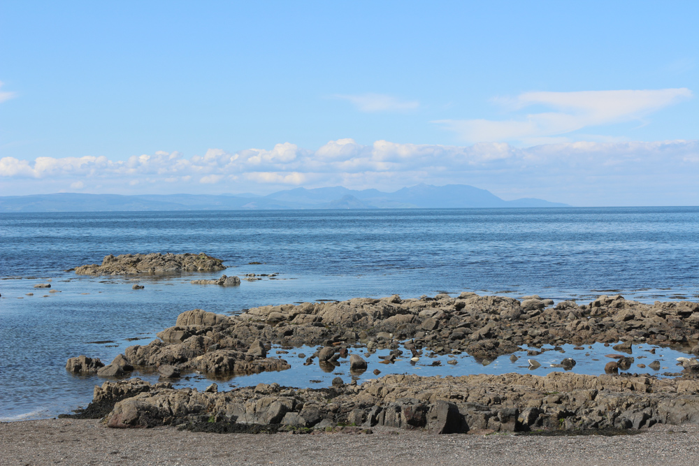 Blick vom steinigen Strand des Culzean Castle über den Firth of Clyde zur Isle of Arran