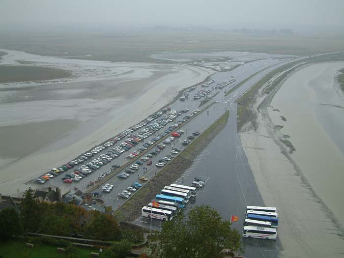 The parking space in front of the city walls of Mont Saint Michel is sometimes also flooded by the tide.

The tides can vary greatly, at roughly 14 meters between high and low water marks. Popularly nicknamed St. Michael in peril of the sea by mediaeval pilgrims making their way across the tidal flats, the mount can still pose dangers for visitors who avoid the causeway and attempt the hazardous walk across the sands from the neighbouring coast. The dangers from the tides and quicksands continue to claim lives.