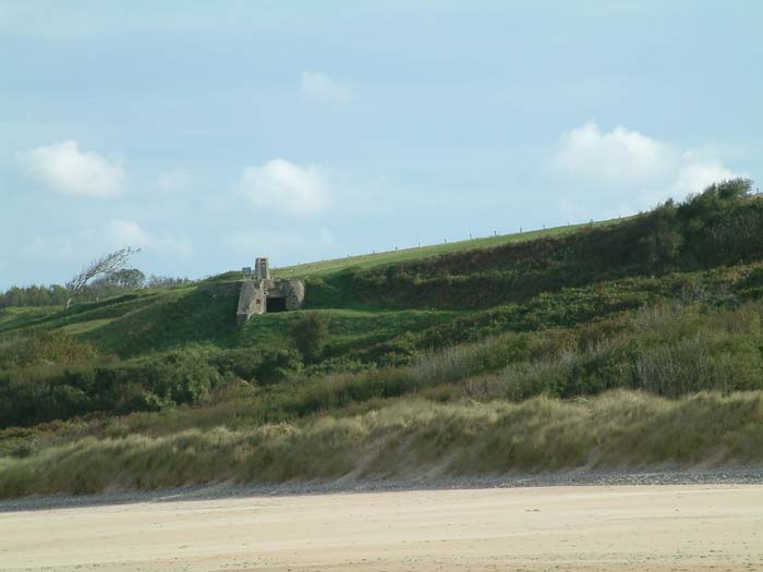 Blick auf den Stützpunkt WN 62 oberhalb von Omaha Beach. Dies war die stärkste Befestigung entlang des amerikanischen Sektors. Das Bild zeigt einen der beiden Bunker, die mit 7,55cm Feldgeschützen bewaffnet waren und damit fast den gesamten Strand abdecken konnten.