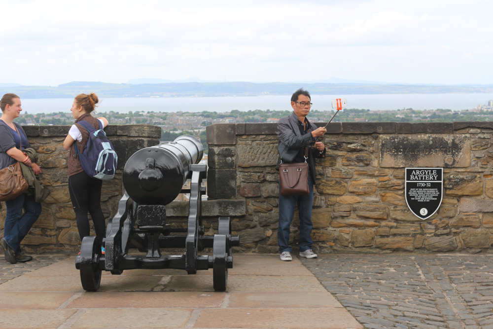 The Argyle Battery of Edinburgh Castle with a man taking a picture using a selfie stick.