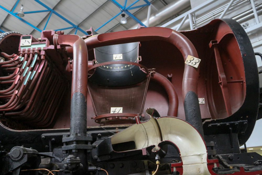 Nationales Eisenbahnmuseum: Ellerman Lines (1949) mit einem Aufschnitt der Dampflokomotive Nr. 35029. (28) ist der Überhitzersammler. (33) sind die Dampfleitungen, die den Dampf vom Überhitzesammler zu den Zylindern leiten. (32) sind Nieten, die zeigen wo der Rohrwand mit dem Boiler verbunden ist. (41) ist die Düse, die den Dampf durch die Rauchkammer (42) durch den Schornstein (43) ableitet.