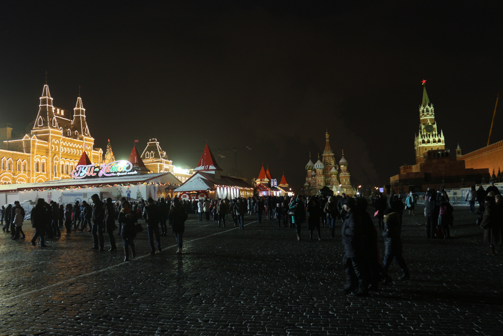 Der Rote Platz bei Nacht mit der Eislaufbahn und der Kathedrale unter einem pechschwarzen Himmel