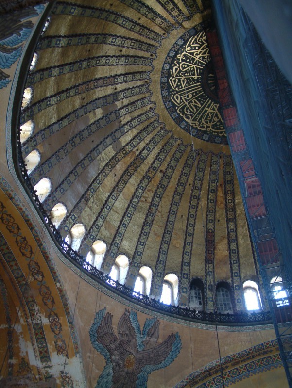 Hagia Sophia is covered by a central dome with a diameter of 31 meters (102 feet), slightly smaller than the Pantheon's. The dome seems rendered weightless by the unbroken arcade of arched windows under it, which help flood the colorful interior with light. The dome is carried on pendentives-four concave triangular sections of masonry which solve the problem of setting the circular base of a dome on a rectangular base. At Hagia Sophia the weight of the dome passes through the pendentives to four massive piers at the corners. Between them the dome seems to float upon four great arches.