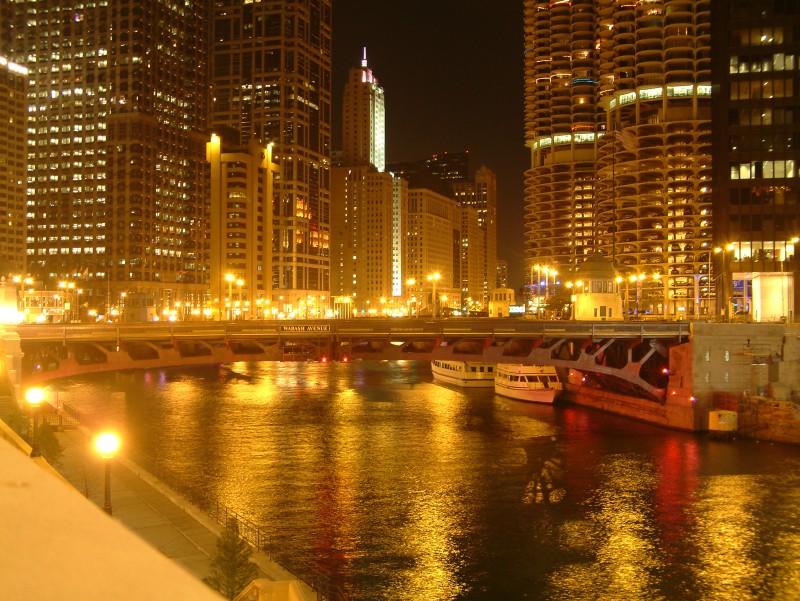 Nachtaufnahme der Wabash Avanue Brücke, die sich über den Chicago River spannt. Im Hintergrund sind Gebäude entlang des Wacker Drive zu sehen.