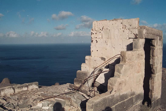 Ruinous concrete building on a cliff above the sea