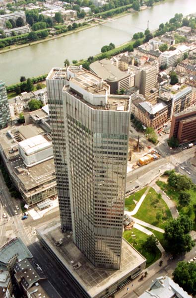 Blick hinab vom Dach der Commerzbank zum kleineren Tower der Europäischen Zentralbank. Halb verdeckt von der EZB ist die Oper Frankfurt. Dahinter fließt dann auch schon der Main, der die Stadt in zwei Hälften teilt.
