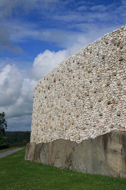 Reconstructured inward-leaning wall of white quartz and granite around Newgrange