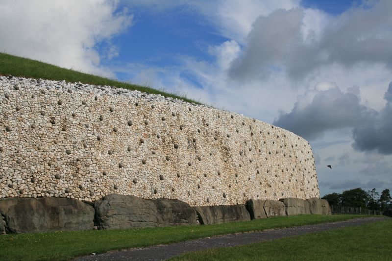 Reconstructured inward-leaning wall of white quartz and granite around Newgrange