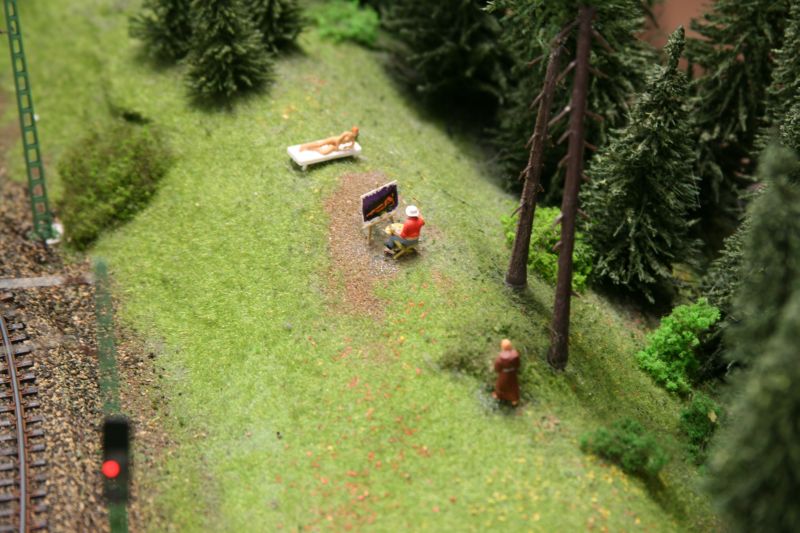 Einer der vielen kleinen Späße im Miniatur Wunderland: Ein Maler portraitiert ein Aktmodell auf einer Wiese. Hinter einem Busch verbirgt sich ein Mönch, der die beiden beobachtet.