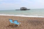 Liegestühle am Strand von Brighton mit Blick auf die Ruine des West Pier