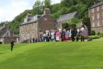 Eine Hochzeitsgesellschaft posiert auf der Grünanlage neben dem Haus des New Lanark Fabrikmanagers Robert Owen.