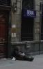 Ein Obdachloser liegt vor einer Bank